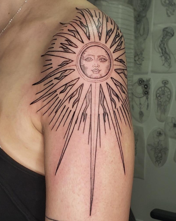 Black fine line shoulder tattoo of a sun and rays by tattoo artist Britney Farmer of Sacred Mandala Studio.